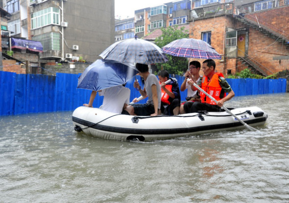 Local residents are evacuated to safety after their homes are flooded in Nanchang, capital city of East China's Jiangxi province, June 28, 2013. [Photo/Xiong Jiafu/Asianewsphoto]