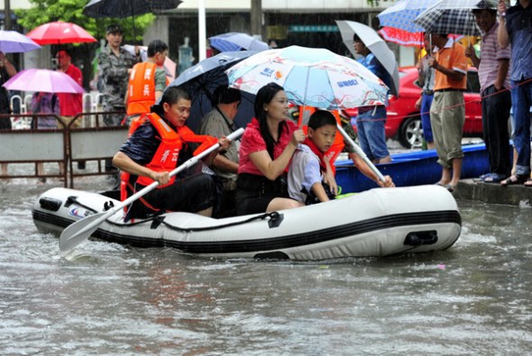 Local residents are evacuated to safety from a flooded road in Nanchang, capital city of East China's Jiangxi province, June 28, 2013. [Photo/Xiong Jiafu/Asianewsphoto]