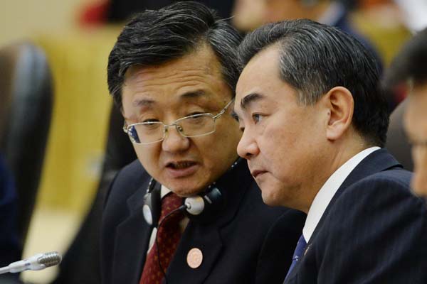 Foreign Minister Wang Yi (right) listens to a member of his delegation during the 14th ASEAN Plus Three Foreign Ministers Meeting in Brunei's capital Bandar Seri Begawan on Sunday. The major regional forum will focus on trying to ease tensions in the South China Sea. Photo by Roslan Rahman / AFP