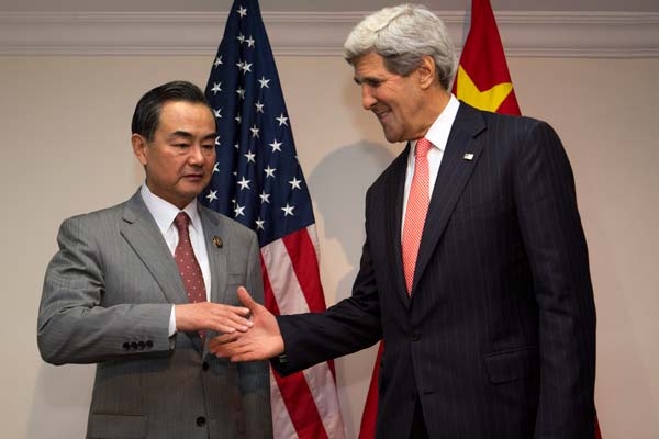 Foreign Minister Wang Yi (left), shakes hands with US Secretary of State John Kerry at the ASEAN meeting at the International Conference Center in Bandar Seri Begawan, Brunei, on Monday. Jacquelyn Martin / Associated Press  