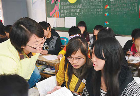 Zheng Wei (left), a graduate from Wuhan University, communicates with her students at a middle school in Shantou, Guangdong province, which is included in the Teach For China program. Provided to China Daily