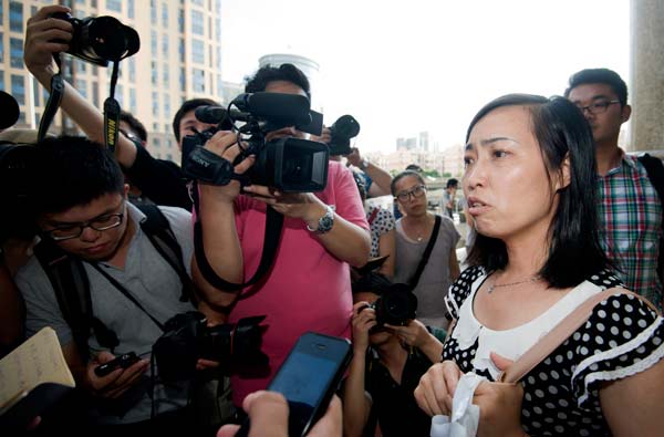 Tang Hui (right) is surrounded by media before walking into the Hunan Provincial Higher People's Court. feng yuanzhi / for china daily