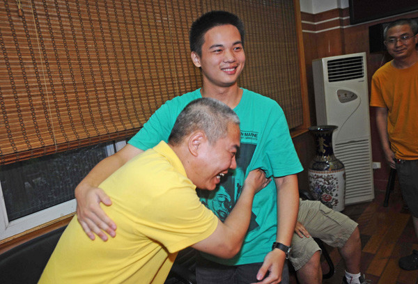 Huang Yiqing (right) comforts his ecstatic teacher of physics Rao Kaihong as they celebrate his top science score in the college extrance exam in Wuhan, Hubei province. Miao Jian / for China Daily