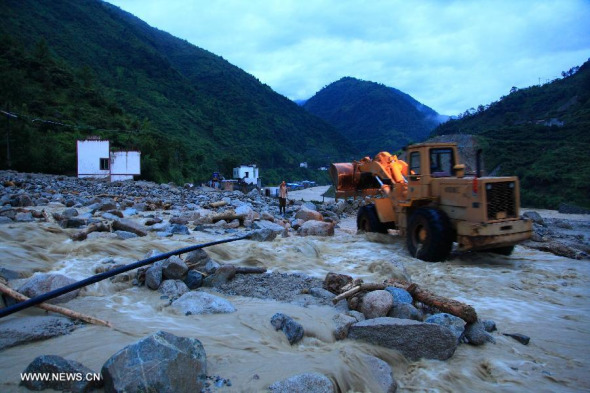 Rescuers repair the 108 national highway in Shimian County of Ya'an City, southwest China's Sichuan Province, July 5, 2013. A rain-triggered landslide and floods in Shimian County have left eight people dead and 11 others missing, local authorities said on Friday. Downpours battered Shimian County Thursday evening, triggering floods and a landslide that resulted in the suspension of traffic on several highways. (Xinhua/Huang Gang) 