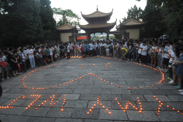 Citizens hold a candlelight vigil for the two Chinese teenage victims of the Asiana plane crash in a park in Jiangshan, Zhejiang province, on Monday. Huang Shuifu / for China Daily 