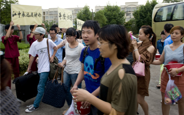 Thirty-one students and teachers who were onboard the Asiana Airlines flight that crashed in San Francisco arrive at Jiangshan Middle School, where parents and families were waiting in Hangzhou, capital of Zhejiang province on July 14,2013. [Photo/Asianewsphoto]