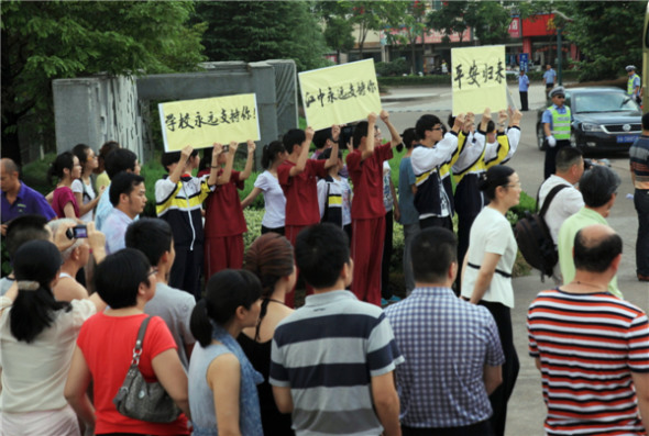 Parents and students from Jiangshan Middle School wait for the return of survivors of the Asiana Airlines flight that crashed in San Francisco in Hangzhou, capital of Zhejiang province on July 14,2013.[Photo/Asianewsphoto]