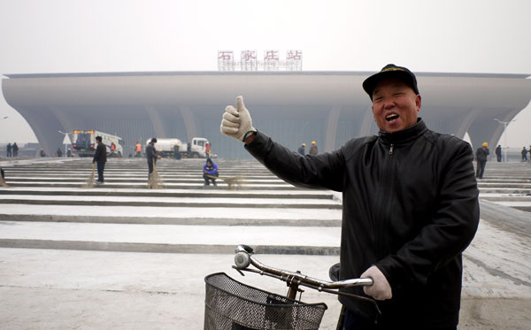 A resident shows his appreciation of Shijiazhuang's new railway station. [Photo Provided to China Daily]