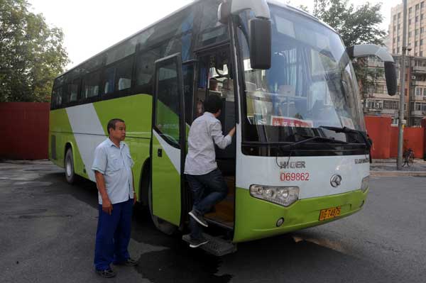 A woman gets on a shuttle bus at the Guomao Central Business District heading to the Tiantongyuan area in northern Beijing. The community worked with Beijing Public Transport Holdings to open three shuttle bus lines in 2011 that now carry 500 commuters a day. Wang Zhenlong / for China Daily