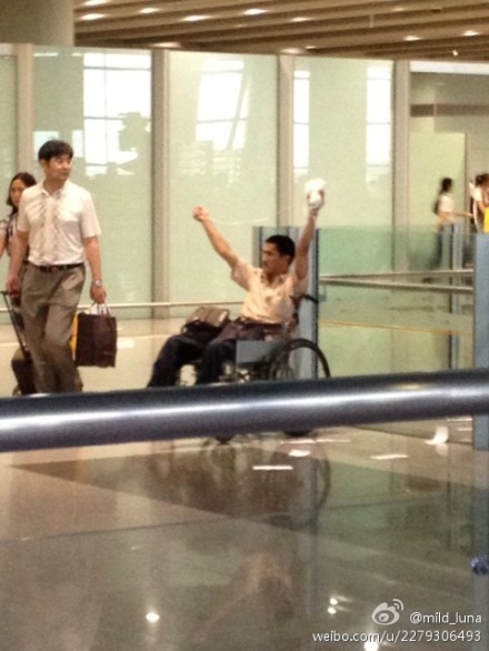 Weibo photo shows a man on a wheelchair holding high a white bag at the Beijing Capital International Airport on Saturday.