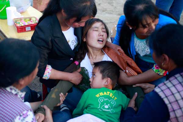 Villagers try to comfort Bao Shufang, who lost her daughter in the earthquake that struck Minxian county, Gansu province, on Monday morning.