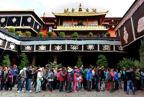 Tourists wait to enter Jokhang Temple in downtown Lhasa. The high season for visitors started in late June, and the city receives an average of 4,000 tourists every day. Wang Song / Xinhua