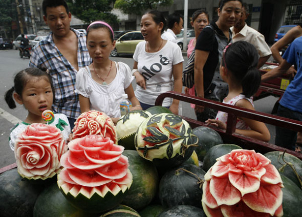 Carved watermelons are sold by Zhang Yunxiao, in Xiangyang, July 22, 2013. [Photo/Asianewsphoto]