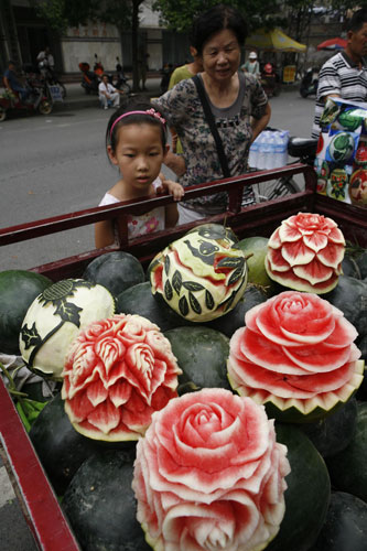 Carved watermelons are sold by Zhang Yunxiao, in Xiangyang, July 22, 2013. [Photo/Asianewsphoto]