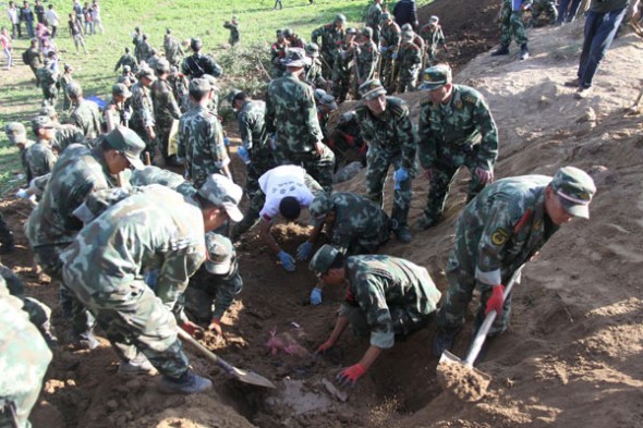 Soldiers search for survivors in Yongguang village, Minxian county, July 22, 2013. Two helicopters and about 3,000 armed police, firefighters, soldiers and local government staffers have been sent to the quake-hit region to help with rescue work. [Photo/Xinhua]