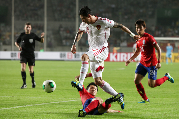 Chinese defender Zhang Linpeng evades a tackle from a South Korean player during an East Asian Cup game on July 24, which ended in a goalless draw. The teams performance at the cup brought relief to soccer fans after a humiliating defeat to Thailand in June.PARK JIN-HEE / XINHUA