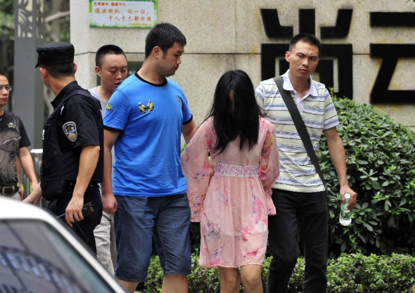 A suspect is arrested in the Chenghua District of Chengdu, capital of southwest China's Sichuan Province, July 31, 2013. A gun fight took place as drug dealers resisted arrest from the police. One suspect jumped from a building and was killed while another two were arrested. (Xinhua/Xue Yubin)