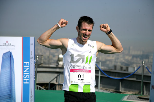 German Thomas Dold celebrates being the first man to finish the vertical marathon at the rooftop of World Trade Center Tower 3 in Beijing on August 3, 2013.[Photo provided to chinadaily.com.cn]