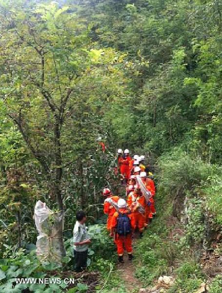 This photo taken by a mobile phone shows rescuers searching for 23 backpackers who went missing in the mountainous Huangniuyan Scenic Spot in Yichang, central China's Hubei Province, Aug. 4, 2013. Rescuers expressed concerns over the missing tourists' safety, as a severe rainstorm pummeled the Huangniuyan Scenic Spot, where the travelers disappeared, on Saturday night. Municipal police and firefighters are working with local residents to search for the missing tourists. (Xinhua)  