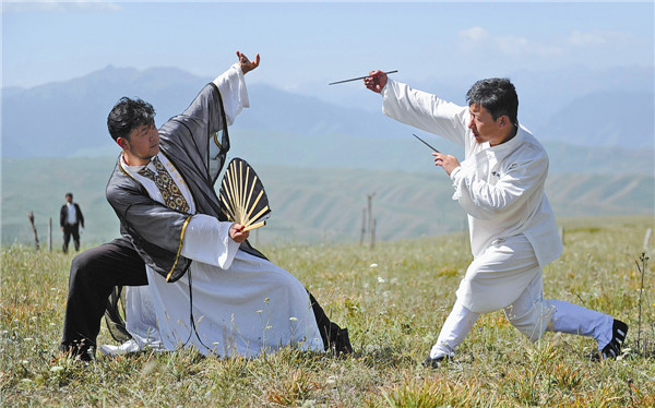 Representatives from different schools of Wushu, a traditional Chinese martial art, demonstrate their skills on the grasslands near Tianshan Mountain for a kung fu show this week. They were criticized online for putting on a show rather than popularizing martial arts. Ma Yuan / for China Daily