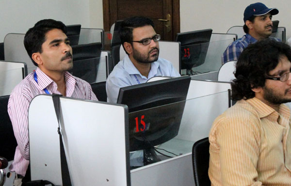 Shameel Farhan (left), a 39-year-old Pakistani security officer, attends a Mandarin course at the National University of Modern Languages in Islamabad in June. [Photo by Zhang Yunbi / China Daily]