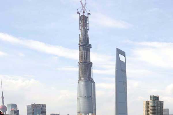 The Shanghai Tower stands over an artificial beach at the Old Docks in Shanghai on Sunday. Construction on the tower, already China's tallest building, is scheduled to be finished by 2015. [LAI XINLIN / FOR CHINA DAILY]