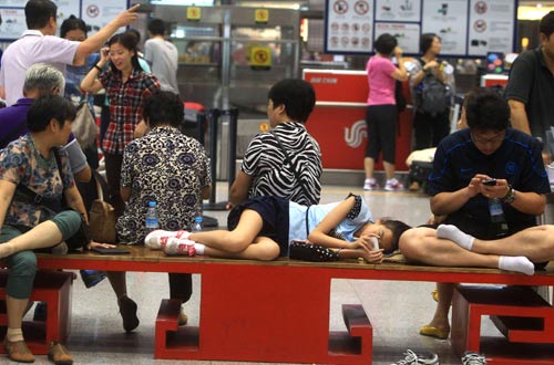 Passengers wait for announcements of their flights in Beijing on Aug 11,2013. Hundreds of flights were canceled or delayed due to storms. [Cai Daizheng / for China Daily]