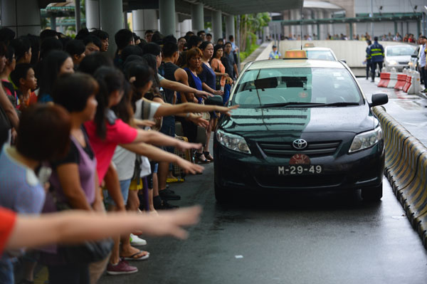 Taxis are in short supply at Portas do Cerco in Macao on Wednesday. Typhoon Utor forced the cancellation of public transportation, resulting in hundreds of people waiting for cabs at the main gateway between the mainland and Macao. The typhoon made landfall in Guangdong province at 3:50 pm. Zhang Jinjia / Xinhua