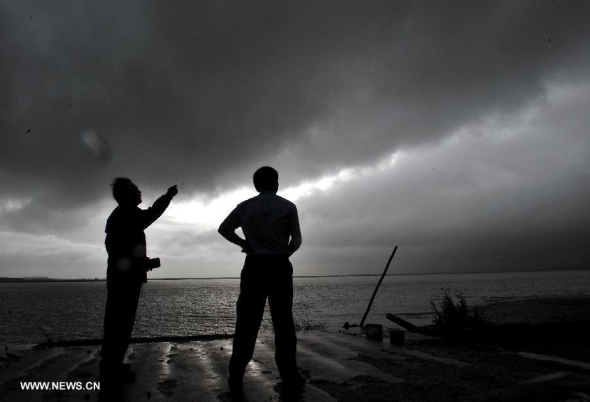 Weather station workers observe the oncoming typhoon Utor at the eye of typhoon Utor in Yangjiang, south China's Guangdong Province, Aug. 14, 2013. Typhoon Utor, the 11th typhoon hitting China this year, landed at 3:50 p.m. in a township in Yangxi county in the city of Yangjiang in western Guangdong, packing strong winds of 151.2 km per hour at the storm center. (Xinhua/Lu Hanxin)