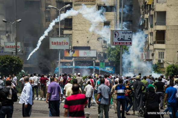 Demonstrators throw back tear gas near Raba'a Al-Adaweya set-in camp in Cairo's Nasr City, Egypt, Aug. 14, 2013. The Egyptian security forces have taken full control of the two major squares where supporters of ousted President Mohamed Morsi had been sitting in for some 45 days, after the dispersing operation started in the early hours of Wednesday, state-run MENA news agency reported. (Xinhua/Li Muzi)     