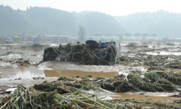 A truck is stuck in mud in flood-hit Qingyuan Manchu Autonomous County, Fushun City of northeast China's Liaoning Province, Aug. 17, 2013. Rain-triggered floods battered several regions in Liaoning, affecting 316,000 people and forcing an evacuation of 80,800 people. (Xinhua/Pan Yulong)