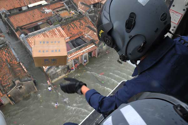 Rescue workers drop relief supplies such as food and water on Wednesday in Shantou, Guangdong province, which was severely affected by flooding. Zhang Liehua / for China Daily