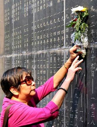 A Nanjing resident places flowers at a war memorial on Tuesday to mark the 68th anniversary of the Chinese people's victory in the War of Resistance against Japanese Aggression in 1945. Lang Congliu / For China Daily 