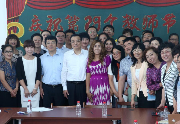 Chinese Premier Li Keqiang poses for a group picture with teachers at No. 20 High School of Dalian, northeast China's Liaoning Province, Sept. 9, 2013. Li stressed raising education quality in underdeveloped regions while visiting teachers in Dalian on Monday ahead of Teachers' Day on Sept. 10. (Xinhua/Pang Xinglei)