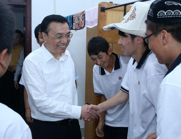 Chinese Premier Li Keqiang talks with students of the ethnic minorities at No. 20 High School of Dalian, northeast China's Liaoning Province, Sept. 9, 2013. Li stressed raising education quality in underdeveloped regions while visiting teachers in Dalian on Monday ahead of Teachers' Day on Sept. 10. (Xinhua/Pang Xinglei) 