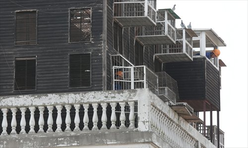 Workers dismantle the 12-year-old pigeon coop Thursday after its owner gave his consent. Photo: Cai Xianmin/GT