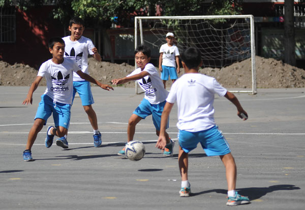 Akdan Ali (center), a female player in the No 5 primary school team in Urumqi, Xinjiang Uygur autonomous region, helps her teammates during a training session. [Photo by Yao Tong / for China Daily]