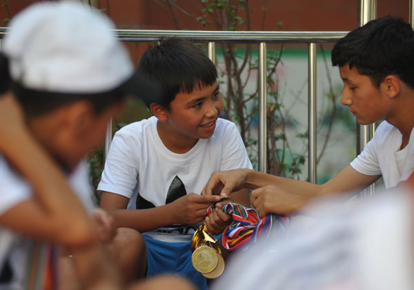 Akdan Ali (center), 11, was the only female player in the No 5 primary school team during the summer tournaments. [Photo by Yao Tong / for China Daily]