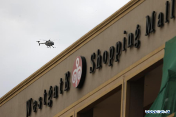 A military helicopter hovers above the Westgate shopping mall in Nairobi, Kenya, Sept. 21, 2013. At least 20 people have been killed and more than 50 others wounded when masked gunmen stormed a popular shopping mall in the Kenyan capital Nairobi and held shoppers hostages on Saturday. (Xinhua/Zhang Chen)