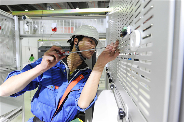 A student fixes a security alarm during the annual competition, in which more than 4,000 students from the city's 72 vocational schools took part. Wang Biao/For China Daily