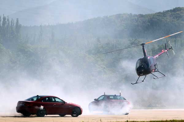 A helicopter and two cars are featured in a performance during the 15th Aviation Expo/China on Thursday. The expo, which opened in Beijing on Wednesday, will last four days. Zou Hong / China Daily