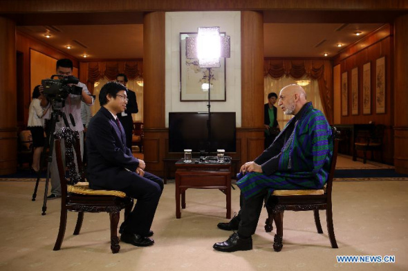 Afghan President Hamid Karzai (R) speaks during an exclusive interview with Xinhua at the Diaoyutai State Guesthouse in Beijing, capital of China, Sept. 28, 2013. (Xinhua/Jin Liwang)