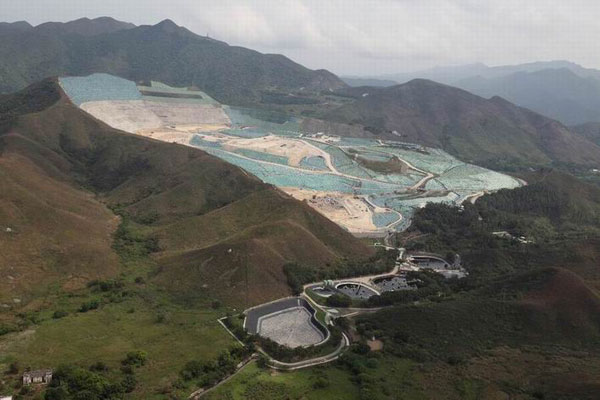 Covered largely by green plastic material, one woman in Shenzhen said she initially thought the Tuen Mun landfill was a scenic spot, until she moved into her new home at Shenzhen Bay and was inundated by the smell of waste. Many people, including the woman, have criticized the Hong Kong authorities' expansion plans. Photo by Edmond Tang / China Daily