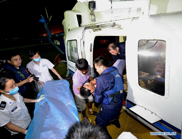 A wounded fisherman is carried out from a helicopter upon his arrival in Sanya, south China's Island of Hainan Province, Sept. 30, 2013. Five fishermen were transferred to Sanya on Monday by helicopters after they were saved from boats sinking in the Xisha Islands. Search is ongoing in the South China Sea amid strong gales for 74 people missing after three fishing boats have sunk since Sunday afternoon due to the Typhoon Wutip. (Xinhua/Zhang Yongfeng)