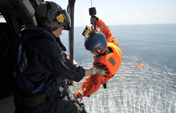 A rescuers gets prepared to save two fishermen from the sinking ship Yuetaiyu 62116 in south China's Hainan Province, Oct. 1, 2013. As of 2 p.m. Tuesday, rescuers had retrieved 14 survivors. Two fishermen were confirmed dead while 58 others are still missing. Search is ongoing for 74 people missing in the South China Sea amid strong gales after three fishing boats have sunk since Sunday afternoon due to the Typhoon Wutip. (Xinhua/Zhao Yingquan) 