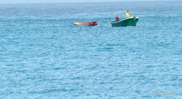 A rescue ship takes boats belonged to the missing fishermen to Yongxing Island, south China's Hainan Province, Oct. 2, 2013. Search is ongoing for 58 people missing in the South China Sea amid strong gales after three fishing boats have sunk since Sunday afternoon due to the Typhoon Wutip. (Xinhua/Zhao Yingquan)