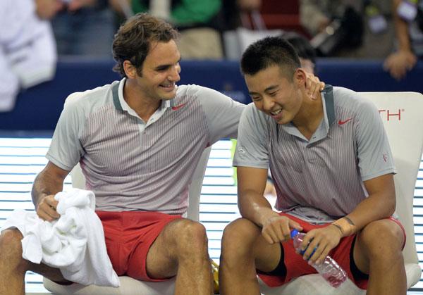 Roger Federer of Switzerland and Zhang Ze of China celebrate beating Kevin Anderson of South Africa and Dmitry Tursunov of Russia 6-2, 6-1 in their first-round doubles match at the Shanghai Masters on Monday. Peter Parks / Agence France-Presse