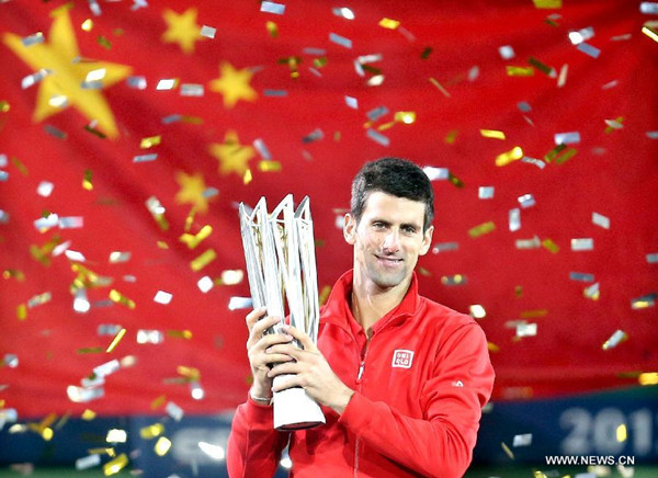 Novak Djokovic of Serbia poses with the trophy after winning the men's singles final match against Juan Martin Del Potro of Argentina at the Shanghai Masters tennis tournament in Shanghai, east China, Oct. 13, 2013. Novak Djokovic won 2-1. (Xinhua/Fan Jun)