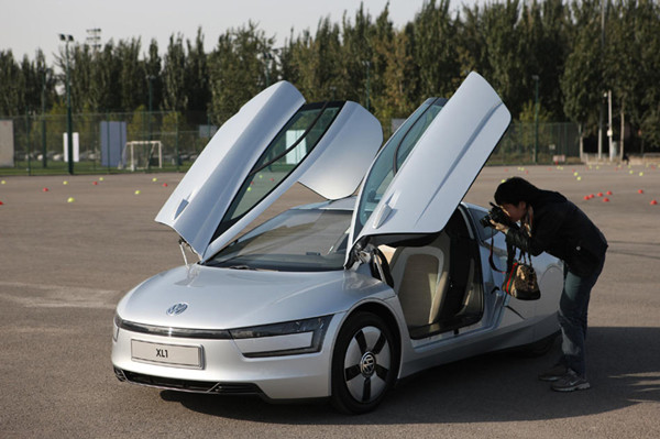 A journalist takes photos of the interior of the world's first 1-litre car, produced by Volkswagen,on October 23, 2013 in Beijing. [Photo / Xinhua]