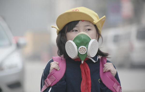 A pupil goes to school wearing a mask amid smog in Jinan, East China's Shandong province, Oct 29. [Photo by Zheng Tao/Asianewsphoto]  